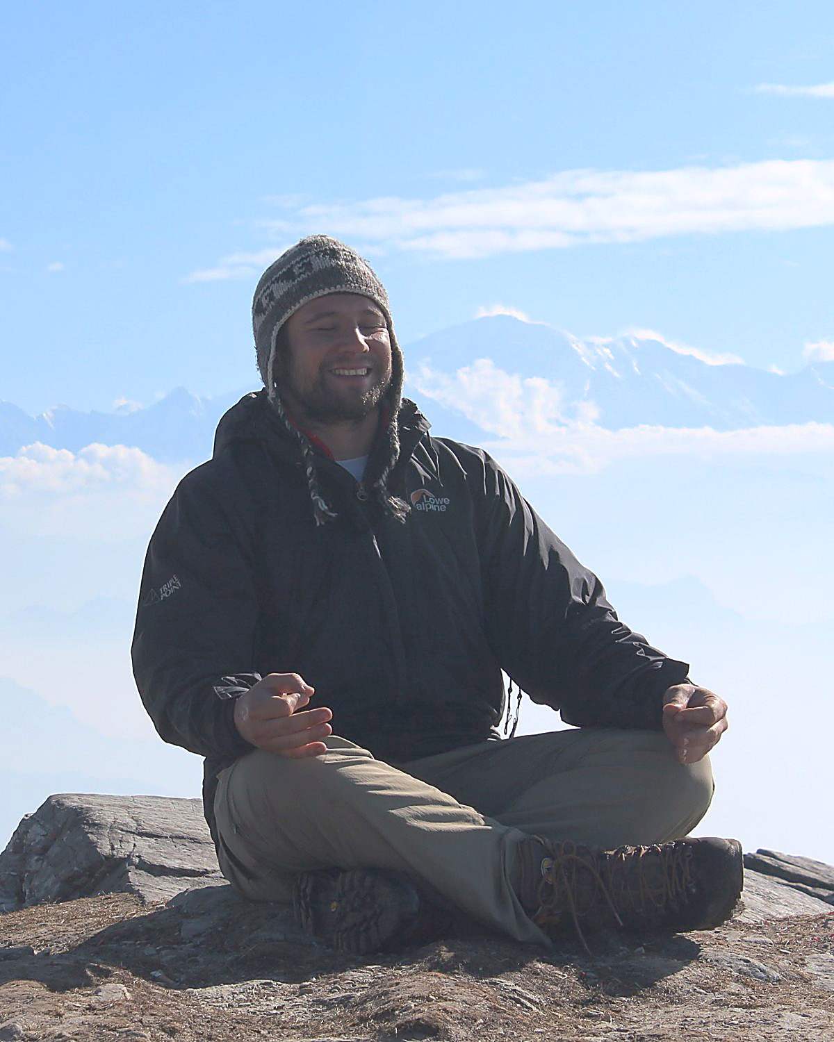 Prof. Daniel De Nardi meditando no alto de uma montanha, com o Himalaia ao fundo